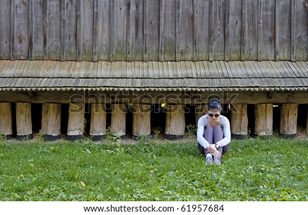 Young girl in bad mood sitting on grass
