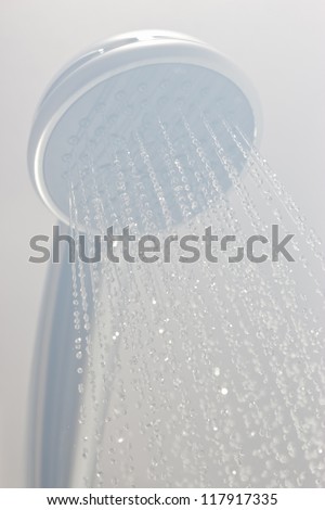 Photograph of a shower head showing drops with streams of hot water. Black and white photo taken in steam