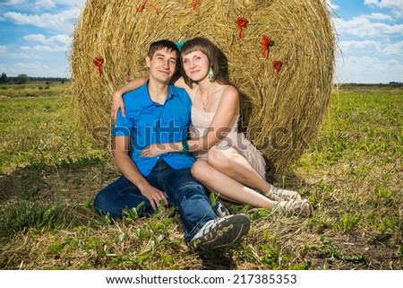Young couple sitting near haystack