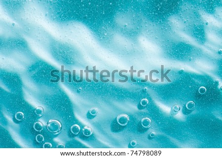 Water ripple with sun spot in Blue abstract water with bubbles. Macro. Closeup. Copy-space.