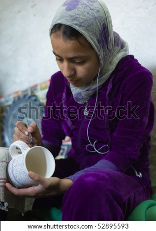 FES - APRIL 17: Islamic girl is painting ceramics in a pottery in Fes April 17, 2010 in Fes, Morocco.
