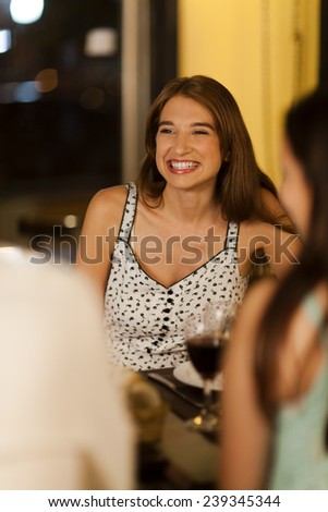 Two young women with friends in a restaurant