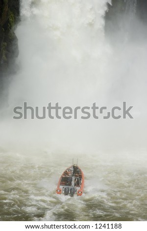 A power boat approaches a waterfall.