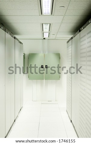 An aisle of racks in a modern datacenter.  Power distribution boards are mounted on the wall at the end.