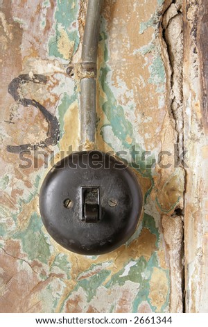 Old electricity switch on grunge wall with lead wire