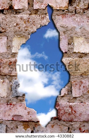 bricks wall broken with blue cloudy sky showing through it