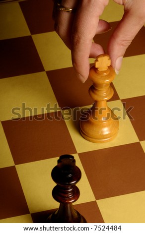 female hand in the act of moving the king in a chess game