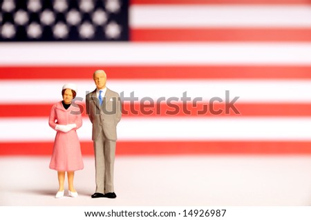 miniature figurine of presidential couple against a flag of USA