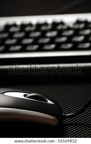 close-up detail of a black and silver modern computer mouse and keyboard
