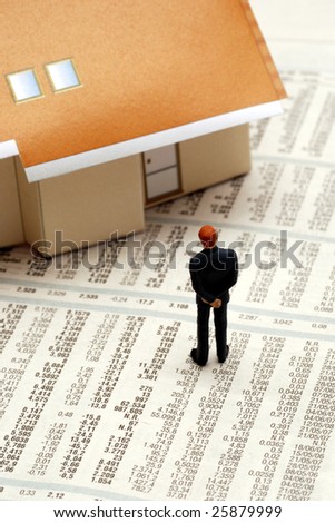 businessman figurine on a financial newspaper with a home model