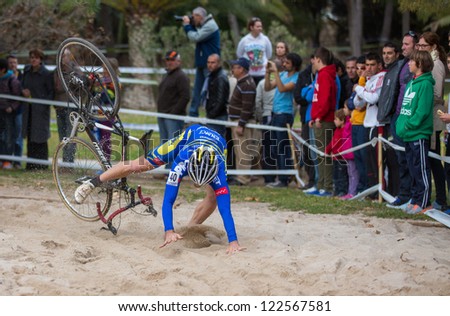 VALENCIA - DECEMBER 16: Unidentified biker falls over sand while participates in XXVII edition of Cyclo-cross city of Valencia