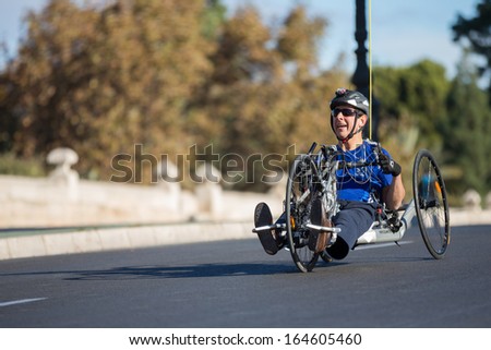 VALENCIA - NOVEMBER 17: Unidenfied hand-biker participates over his handicapped wheel chair in Valencias Marathon on November 17, 2013 in Valencia, Spain