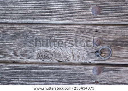 Closeup of vintage run-down wooden door iron doorknocker