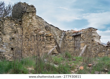 Entire view of ruined house with fallen walls against blue sky