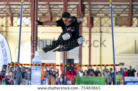 VALENCIA, SPAIN - APRIL 16: Front view of amateur Inline Skater doing acrobatics and jumping over a bar in the roller skate exhibition day celebrated each year on April 16, 2011 in Valencia, Spain