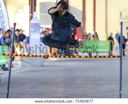 VALENCIA, SPAIN - APRIL 16: Front view of amateur Inline Skater doing acrobatics and jumping over a bar in the roller skate exhibition day celebrated each year on April 16, 2011 in Valencia, Spain