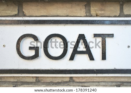 The word Goat written on letters on a plaque, as part of a road sign