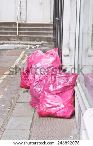 Litter in pink bags for collection, on a city street