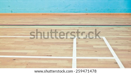 Markings on the wooden floor of a sports hall in black and white