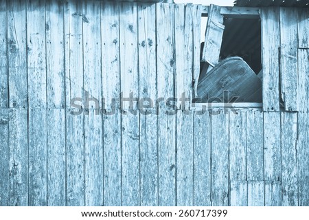 Broken side of an old wooden hut in England in blue tones