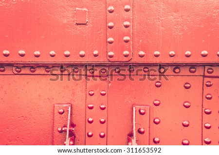 A studded red metallic surface as a background, with a vintage filter applied