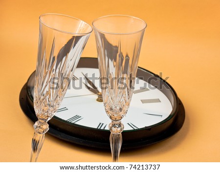 New years eve- clock showing 1 minute past midnight with champagne glasses