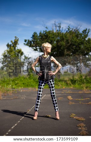 Sexy blond model standing / posing / sitting / laying on an old abandoned tennis court wearing high fashion clothing.