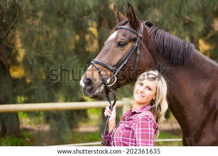Sexy blond farm girl posing with her horse on a farm in South Africa