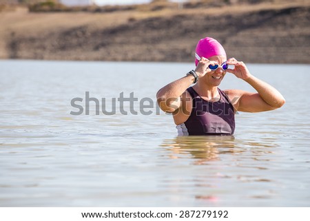 Female Triathlete swimming in a dam while training for a triathlon.