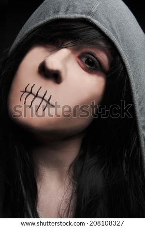 Female zombie without mouth looks into the camera