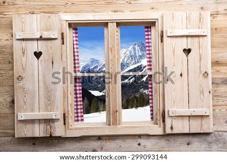 Wooden window with snowy mountains as reflections