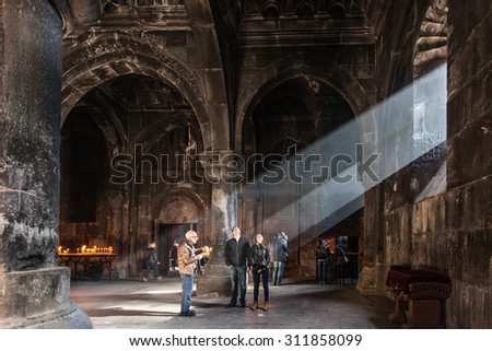 NOVEMBER 8, 2014 - GEGHARD, ARMENIA: Undefined tourists inside Armenian apostolic church. Light falling from the window inside the Geghard monastery .