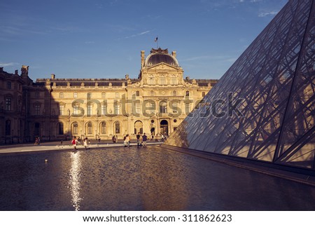 June 28, 2015 - PARIS, FRANCE: Undefined people sitting in front of Louvre in Paris, France. Vintage style photo of sunset in Louvre.