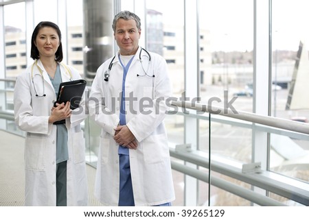 Two medical professionals stand in a futuristic hospital.