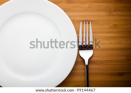 Empty plate and fork on wood table