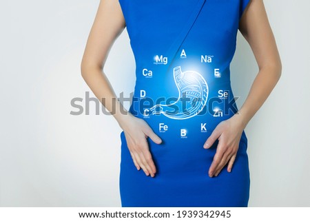 Graphic visualization of healthy human stomach surrounded with icons of vitamins and minerals. Blurred female figure, 
positive blue bright color of recovery, health and detox concept. Stock foto © 