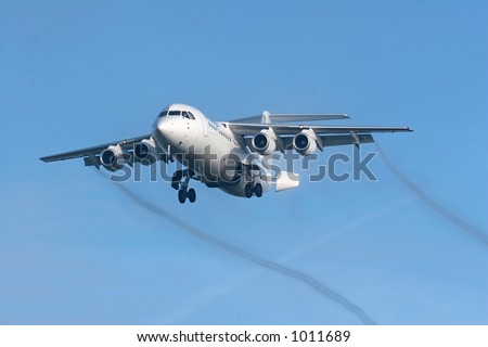 A small 4 engine regional jet about to touchdown on Brussels airport.