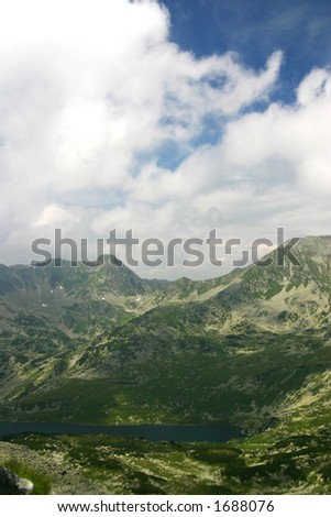Big glacial lake in Retezat mountains - Romania lost between rock peaks