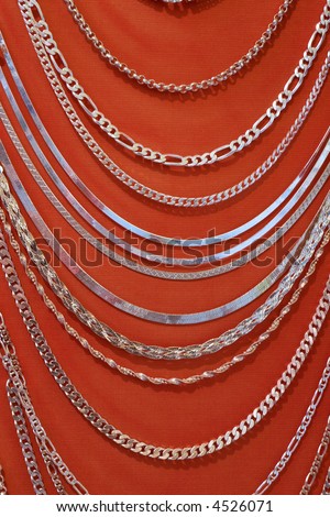Silver necklace models over red background