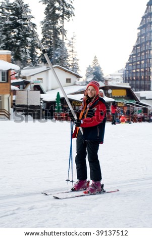 YOung women first ride on the ski in winter holiday