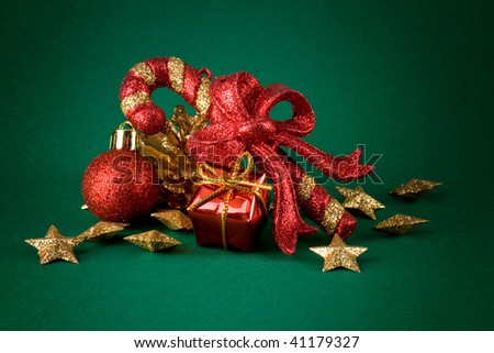 Sparkle christmas candy, golden stars and red globes over green background