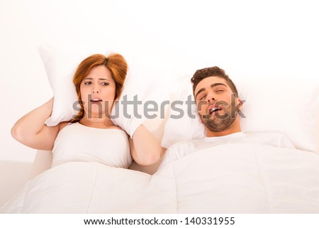 Portrait of an annoyed woman awaken by her fiance\'s snoring