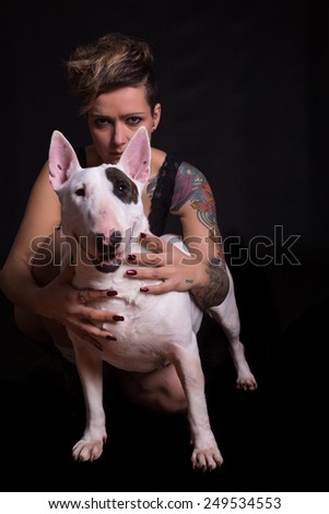 Studio shot of a tattooed woman with her friend, a bull terrier