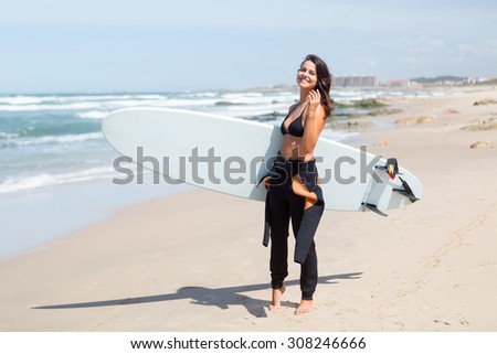 Beautiful young woman preparing to another day of surf