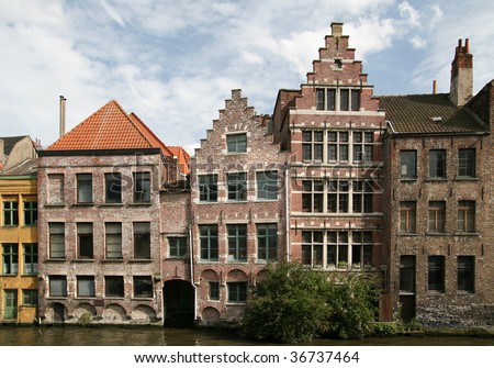 Uneven traditional European brick houses on the bank of the canal