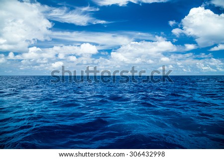 view on the deep blue ocean in front of blue cloudy sky