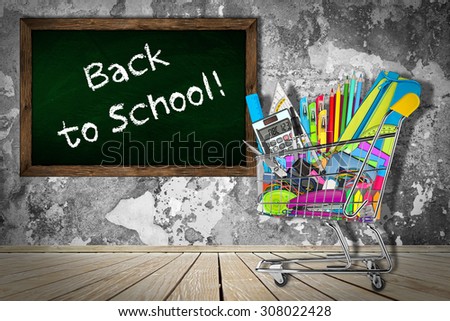 office / school supplies in shopping cart in front of classroom with blackboard