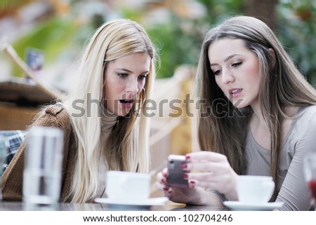 very cute smiling women drinking a coffee sitting inside in cafe restaurant
