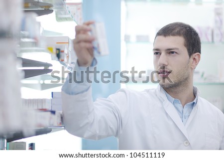 portrait of handsome young  pharmacist chemist man standing in pharmacy drugstore