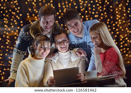 Group of happy people looking at a tablet computer